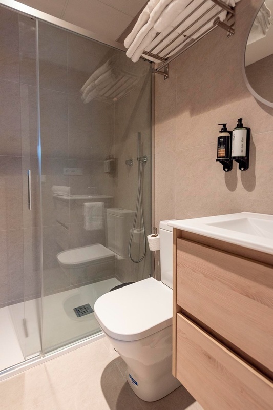 una cama con sábanas blancas y almohadas blancas