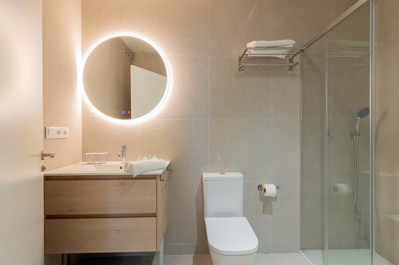 una cama con sábanas blancas y almohadas blancas