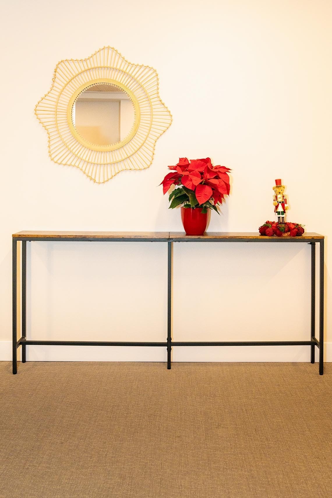 una planta roja se sienta en una mesa junto a un espejo