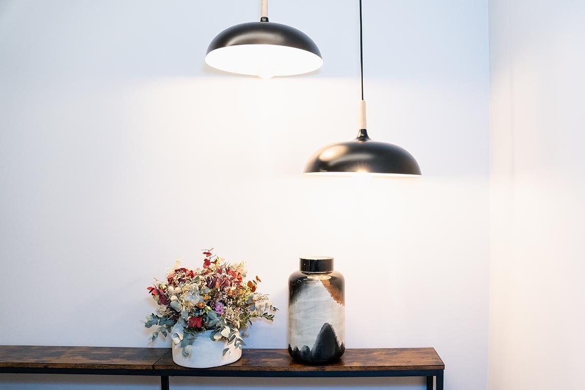 una mesa de madera con un jarrón y dos lámparas