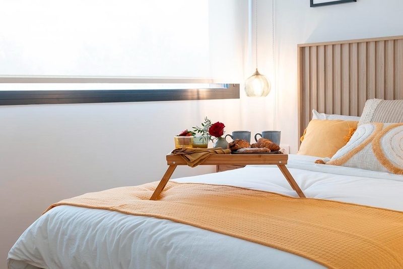 una cama con sábanas blancas y almohadas blancas