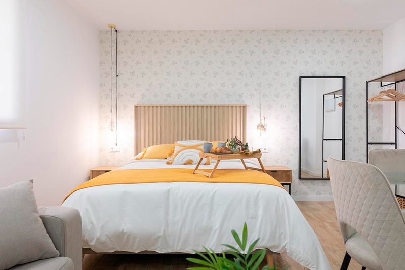 una cama con sábanas blancas y almohadas blancas