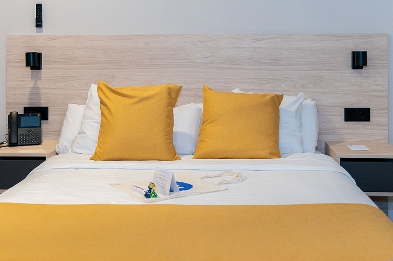 una habitación con una cama y un árbol en la pared