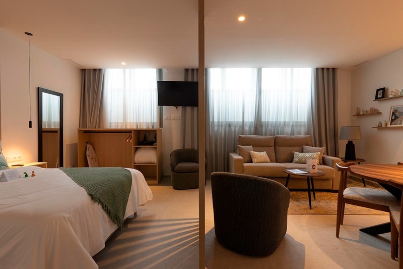 una cama con sábanas blancas y almohadas blancas