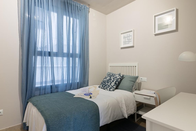 una cama con dos almohadas blancas y una cabecera de madera