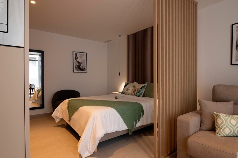 una cama con sábanas blancas y almohadas blancas