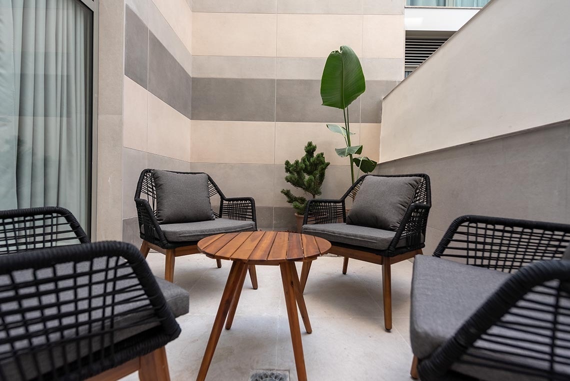 un balcón con sillas y una mesa de madera