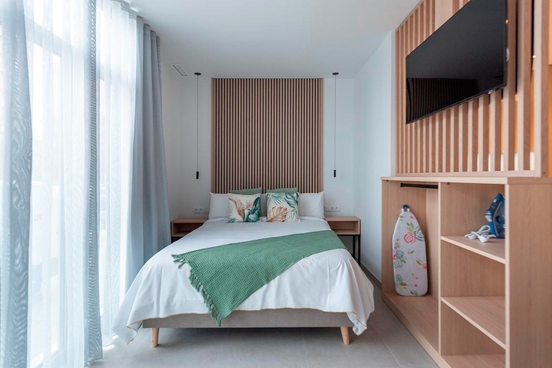 una cama con sábanas blancas y almohadas blancas