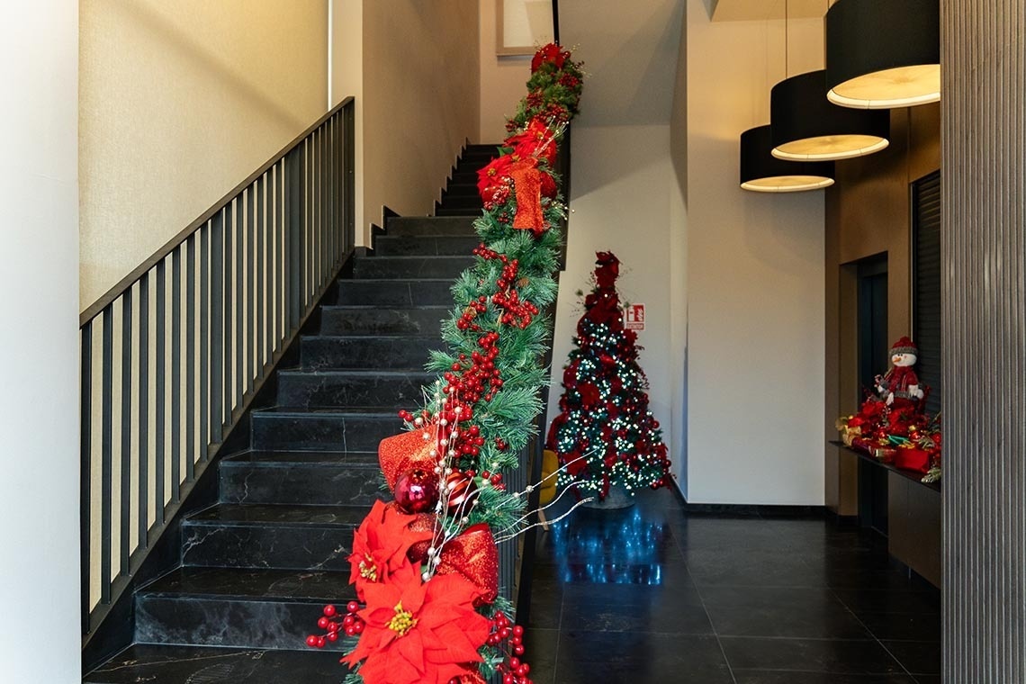 las escaleras están decoradas con flores rojas y árboles de navidad