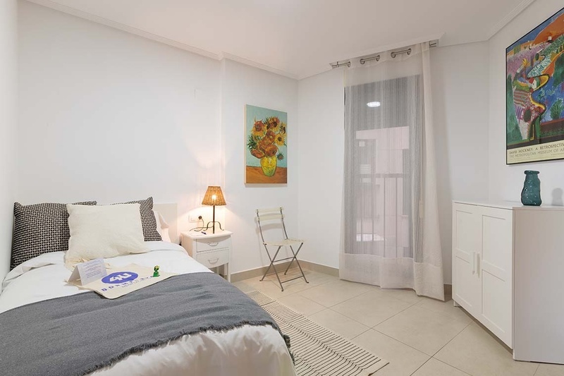 una cama con dos almohadas blancas y una cabecera de madera