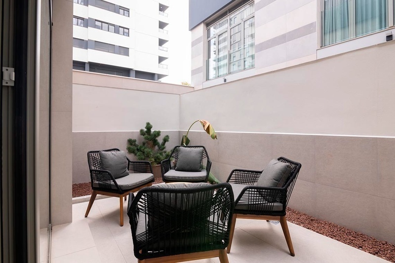 una cama con sábanas blancas y almohadas blancas