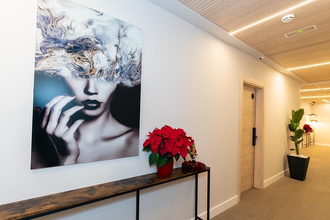 una pintura de una mujer cubre los ojos en un pasillo