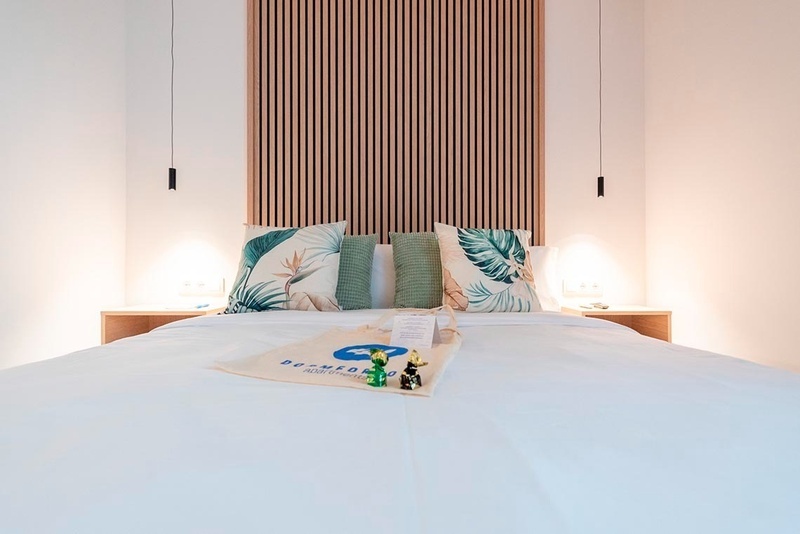 una cama con sábanas blancas y almohadas blancas