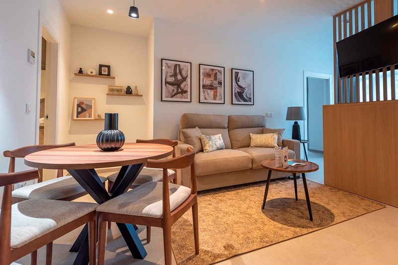 una cama con sábanas blancas y almohadas blancas