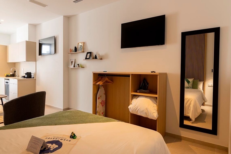 una cama con sábanas blancas y almohadas blancas