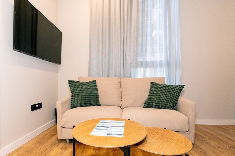 una cama con dos almohadas blancas y una cabecera de madera