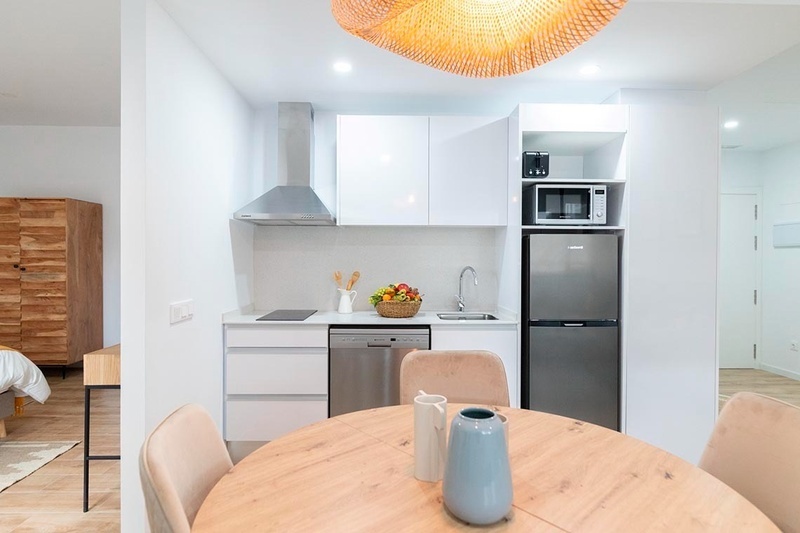 una cama con sábanas blancas y almohadas blancas