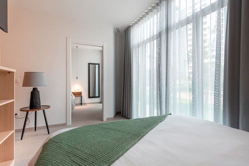 una cama con sábanas blancas y almohadas blancas