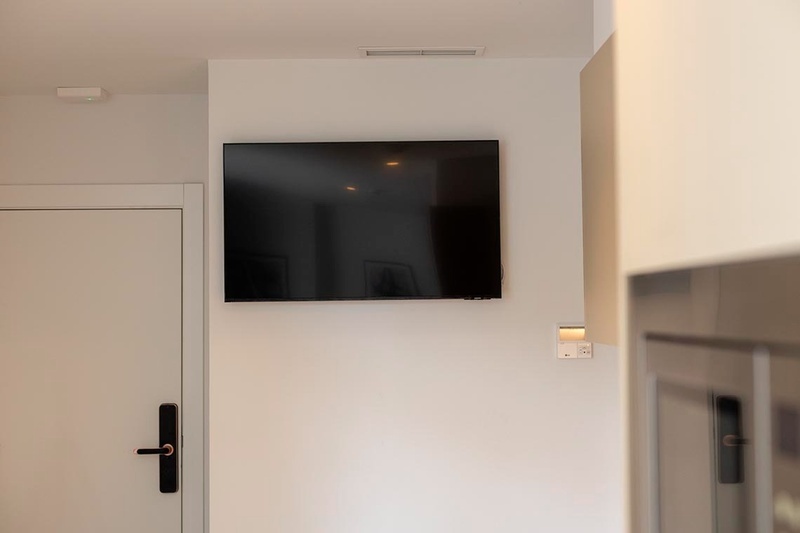 una cama con sábanas blancas y almohadas blancas