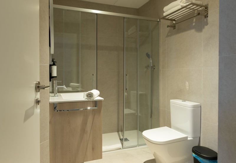 una cama con dos almohadas blancas y una cabecera de madera