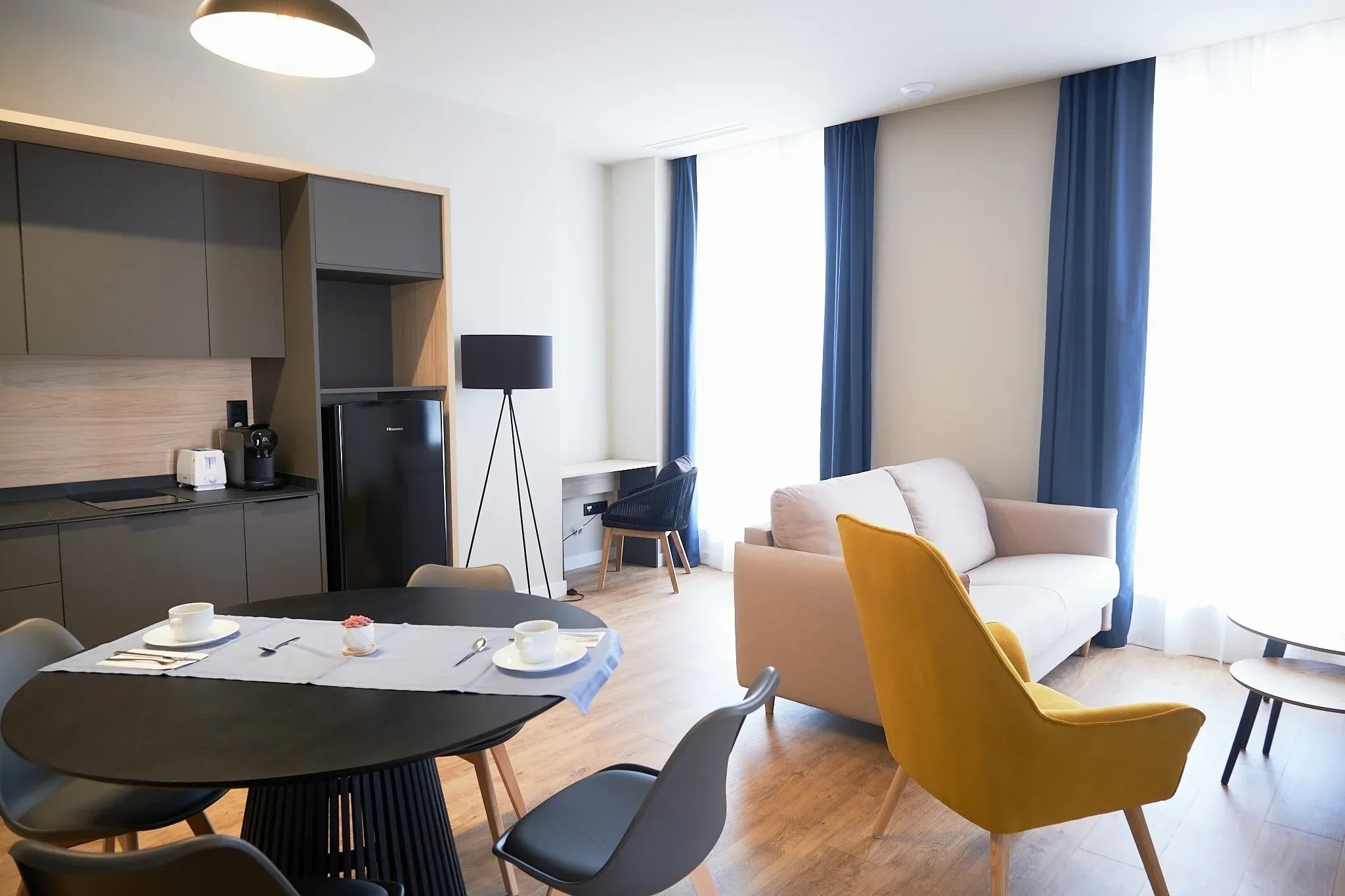 una sala de estar con una mesa y sillas y una nevera