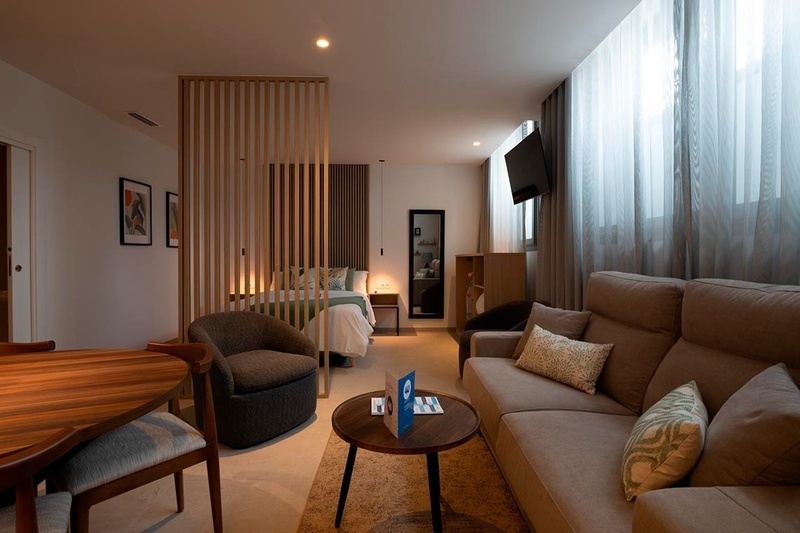 una cama con sábanas blancas y almohadas blancas