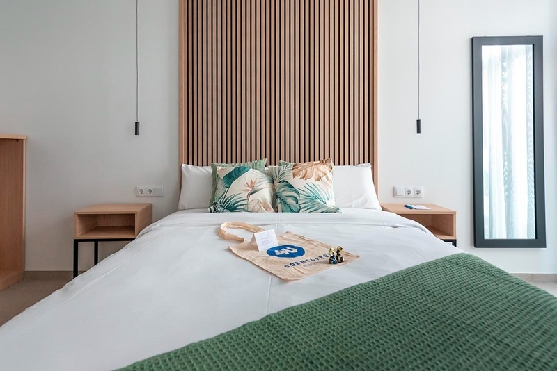 una cama con sábanas blancas y almohadas blancas