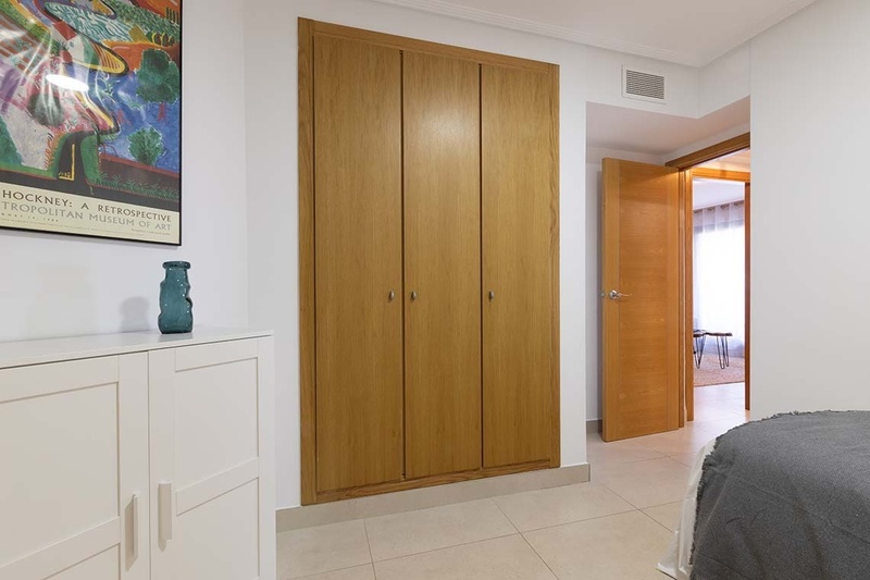 una cama con dos almohadas blancas y una cabecera de madera