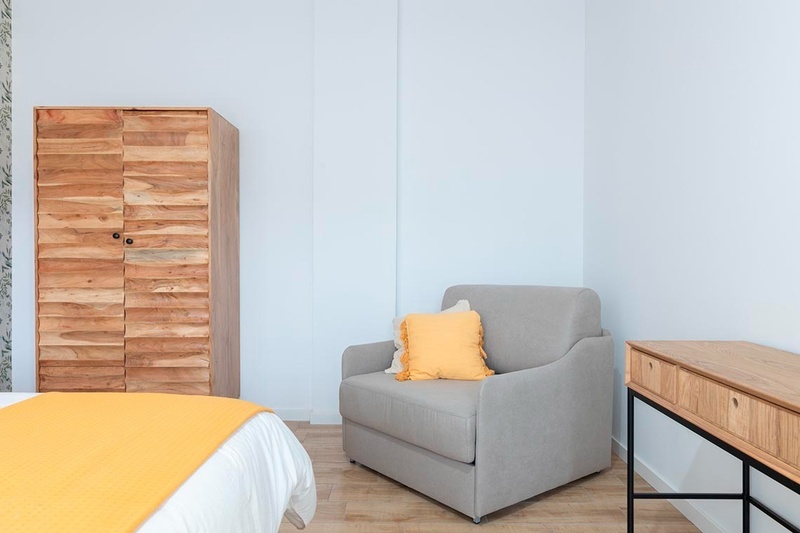 una cama con sábanas blancas y almohadas blancas