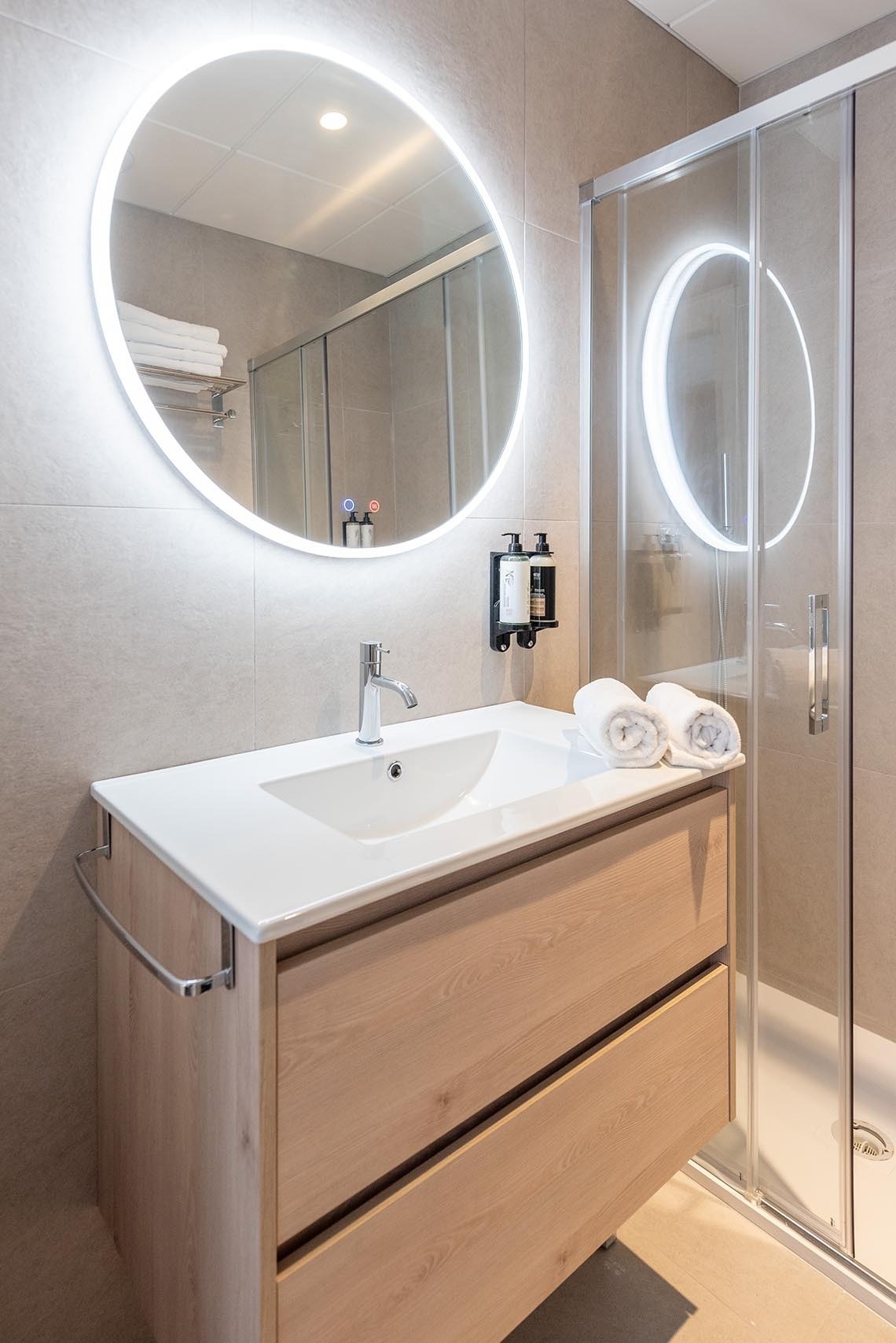 un baño con un lavabo y un espejo ovalado