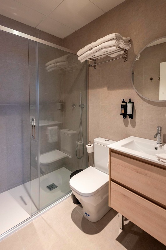 una cama con sábanas blancas y almohadas blancas