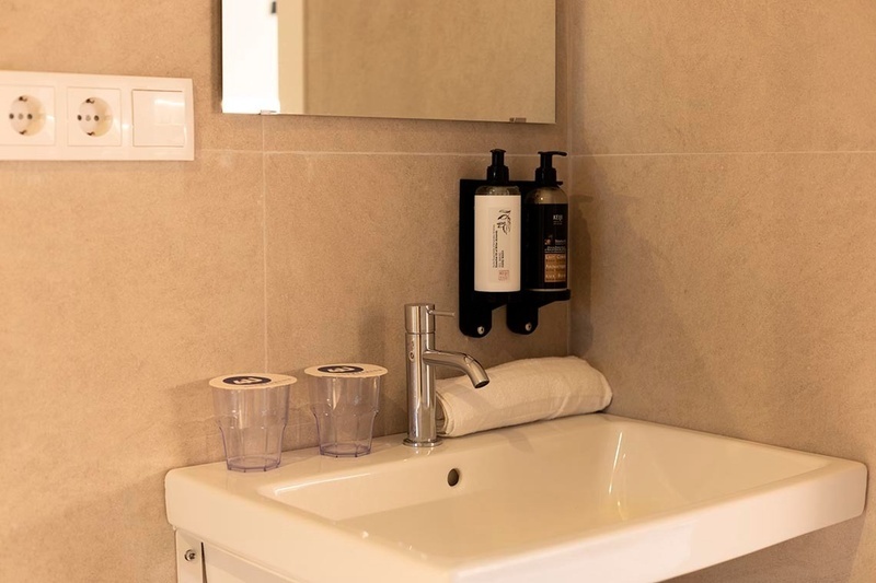 una cama con sábanas blancas y almohadas blancas