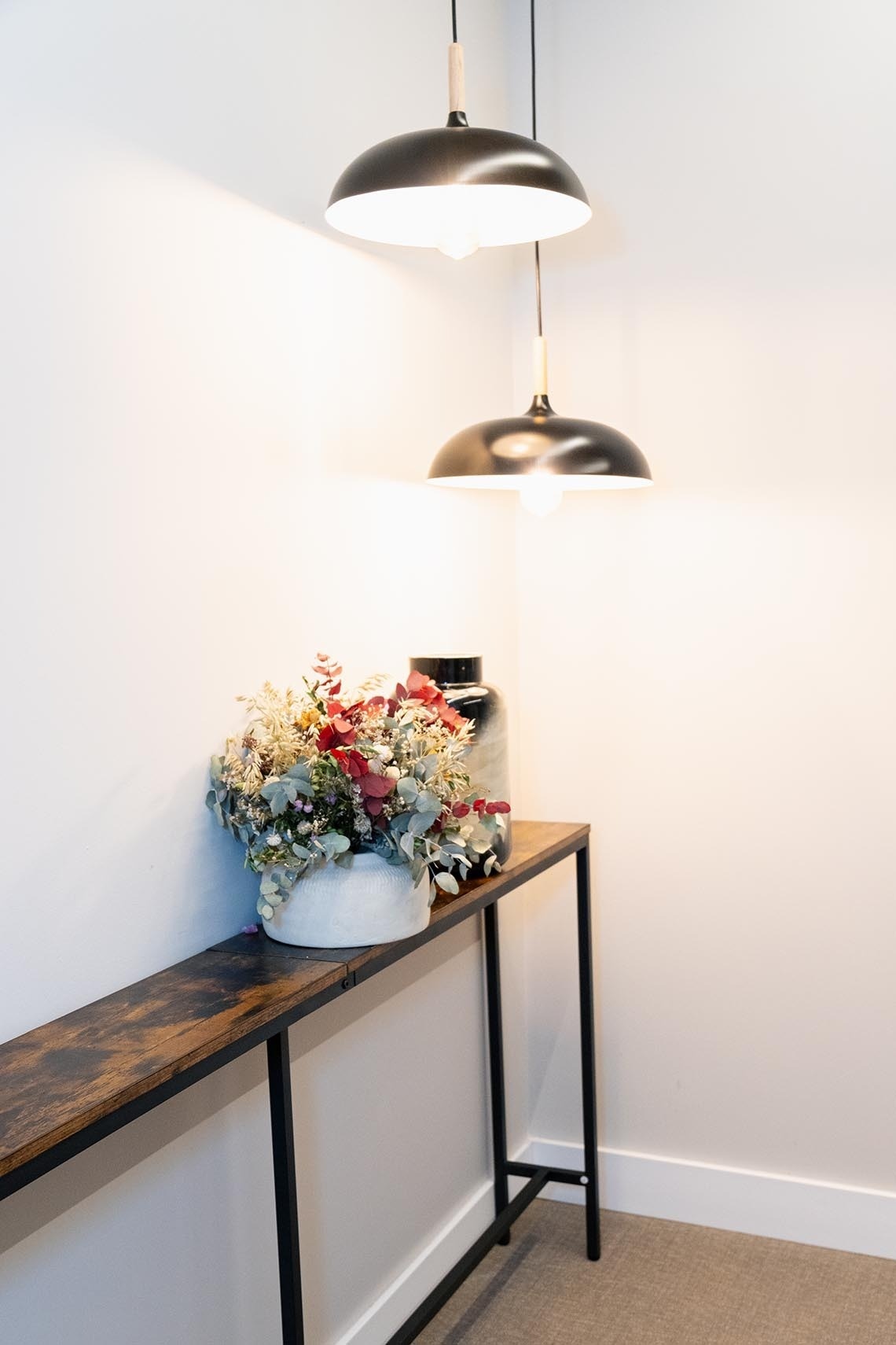 una mesa de madera con un jarrón de flores encima