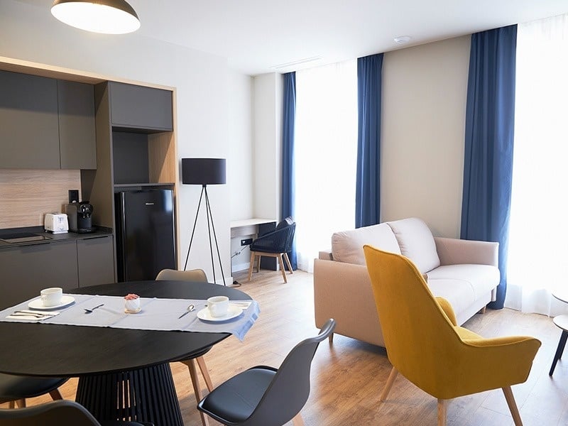 una sala de estar con una mesa y sillas y un sofá