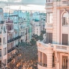 un edificio blanco con balcones y un edificio verde en el fondo