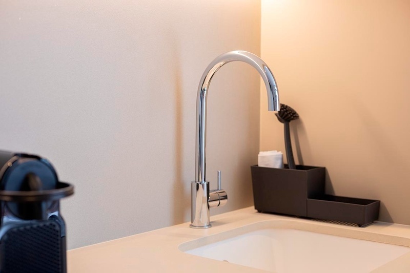 una cama con sábanas blancas y almohadas blancas