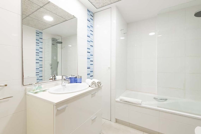 una cama con dos almohadas blancas y una cabecera de madera