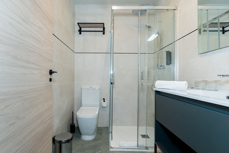 una cama con dos almohadas blancas y una cabecera de madera