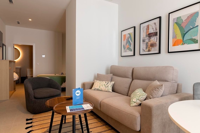 una cama con sábanas blancas y almohadas blancas