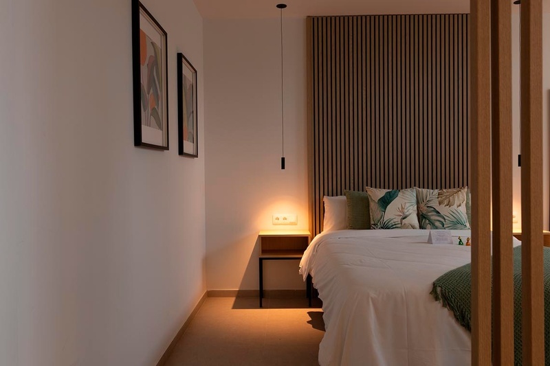 una cama con sábanas blancas y almohadas blancas