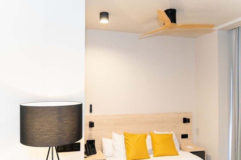 una habitación con una cama y un árbol en la pared