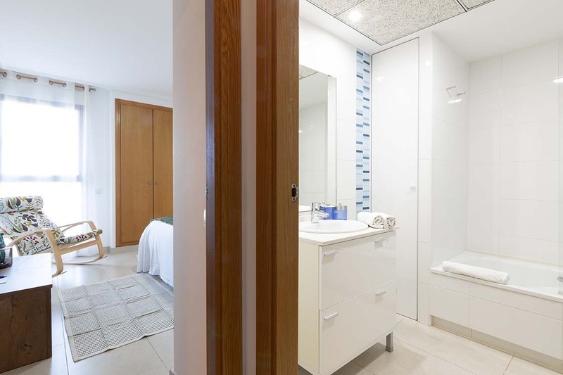 una cama con dos almohadas blancas y una cabecera de madera