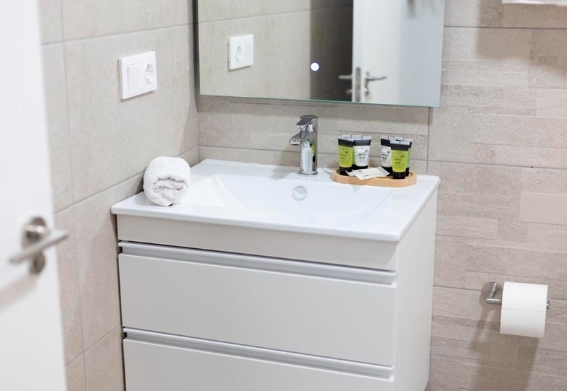 una cama con sábanas blancas y almohadas blancas