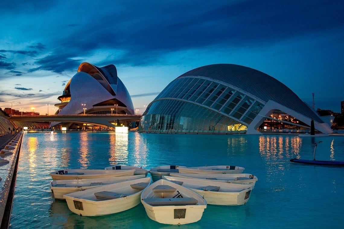 a row of white boats are floating in a large body of water