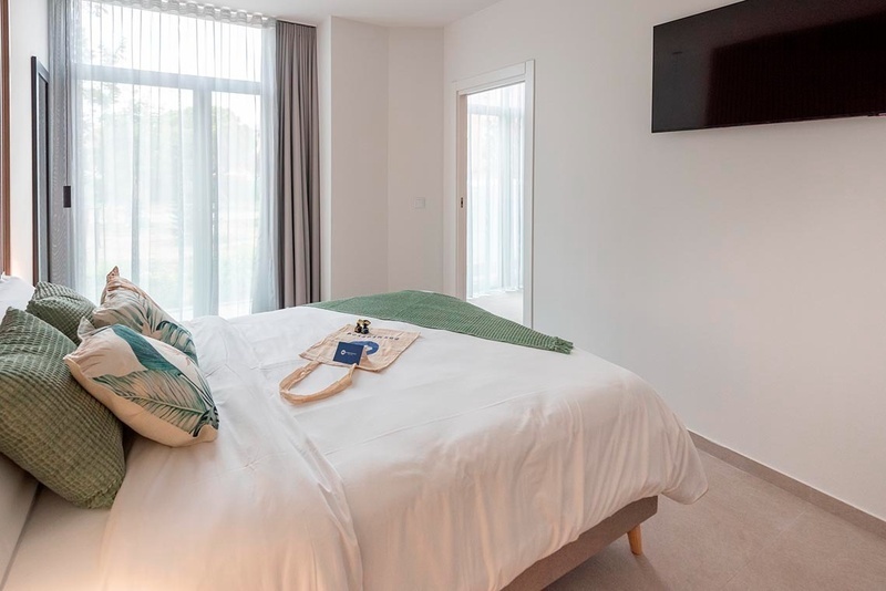 una cama con sábanas blancas y almohadas blancas