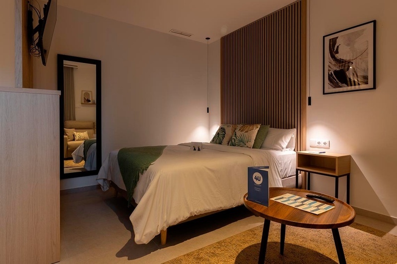 una cama con sábanas blancas y almohadas blancas