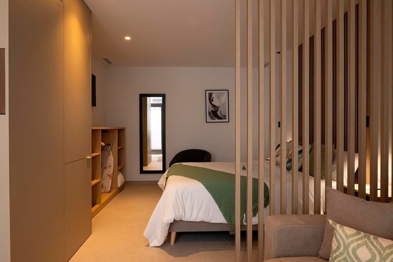 una cama con sábanas blancas y almohadas blancas