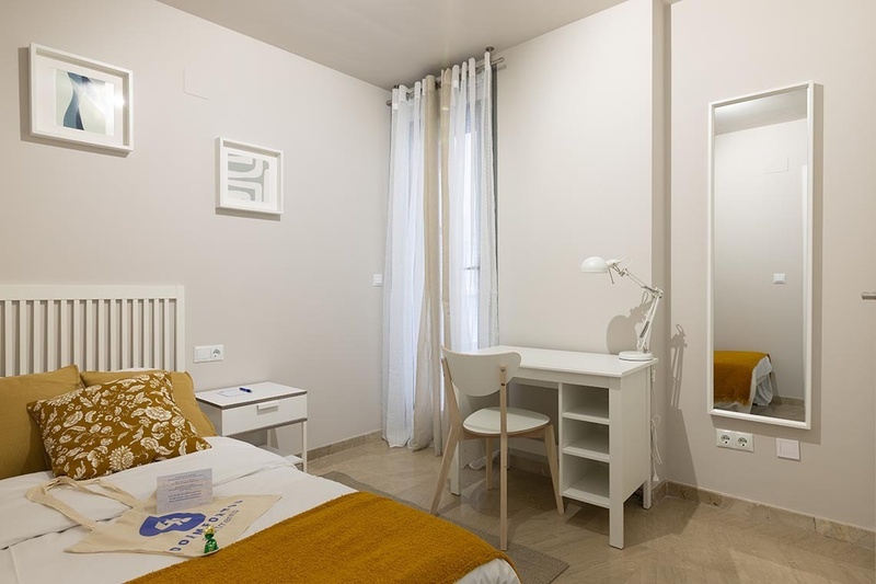 una cama con dos almohadas blancas y una cabecera de madera