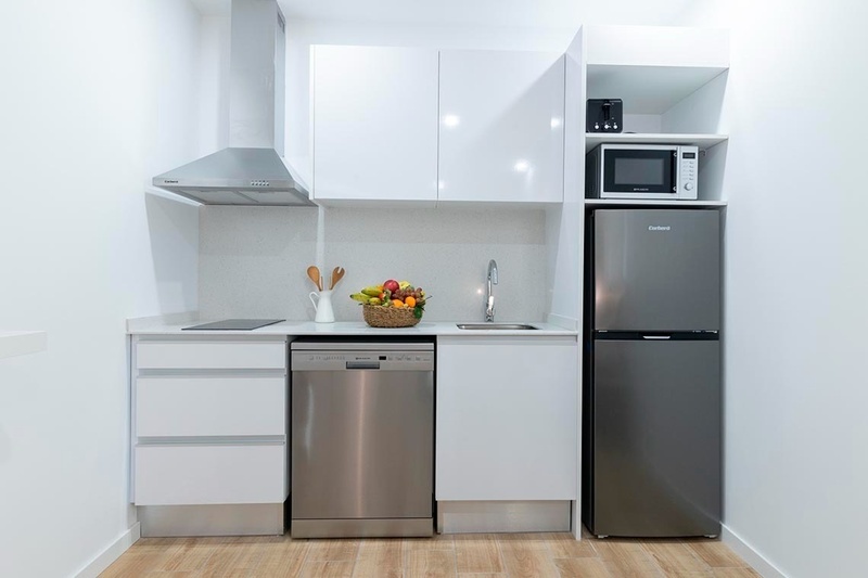 una cama con sábanas blancas y almohadas blancas