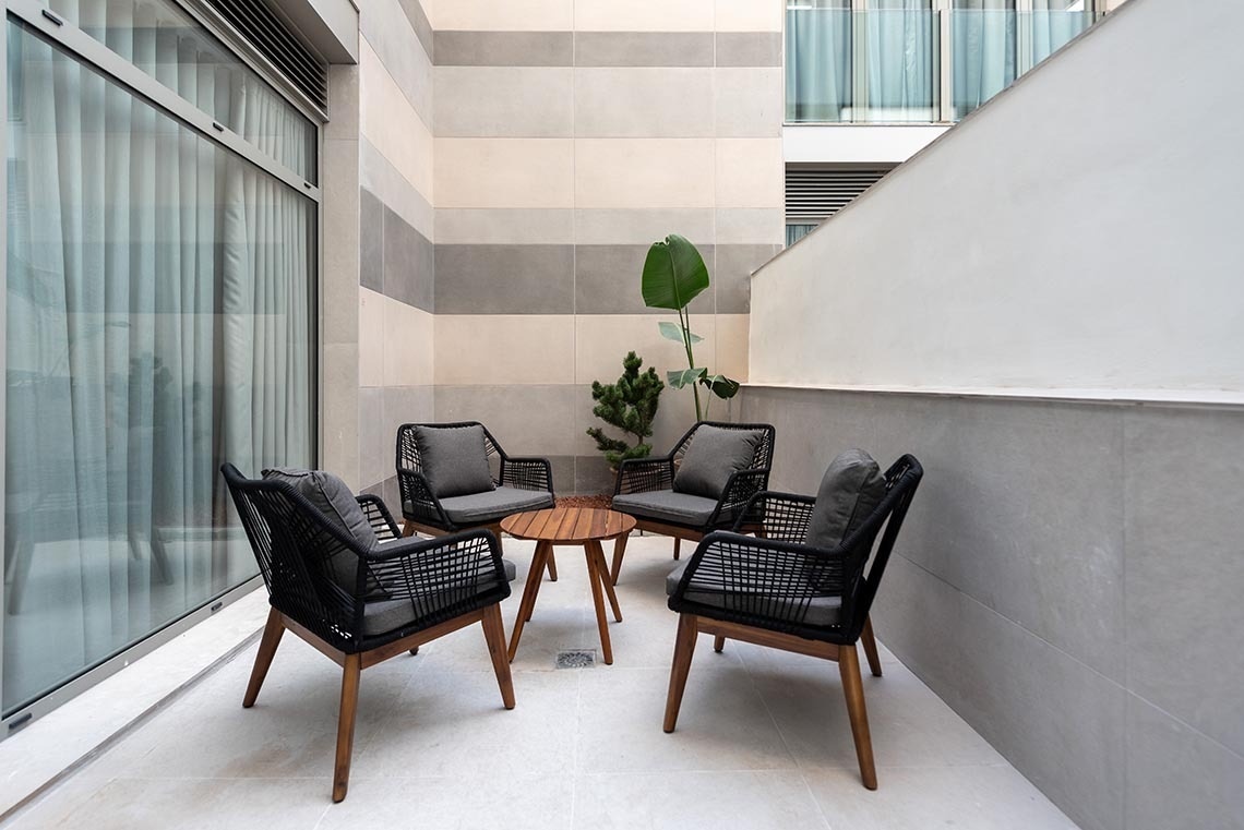 un pequeño balcón con sillas y una mesa de madera